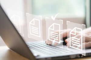 Hands using laptop computer with virtual screen showing document icons depicting online forms